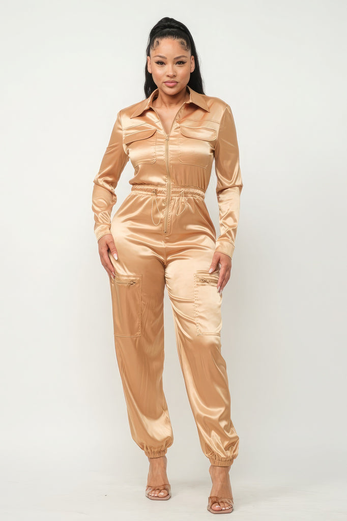model wearing gold Zip Front Satin Cargo Jogger Jumpsuit with clear heels