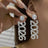 Close-up of a person wearing sparkling 2026 earrings with a hand holding one of them.