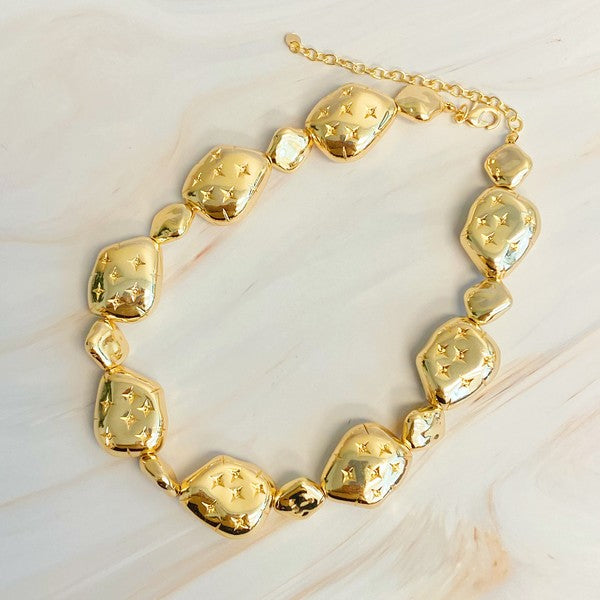 Golden Starlight Pebble Necklace displayed on a table