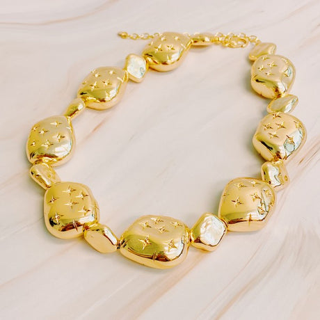 Golden Starlight Pebble Necklace on a table