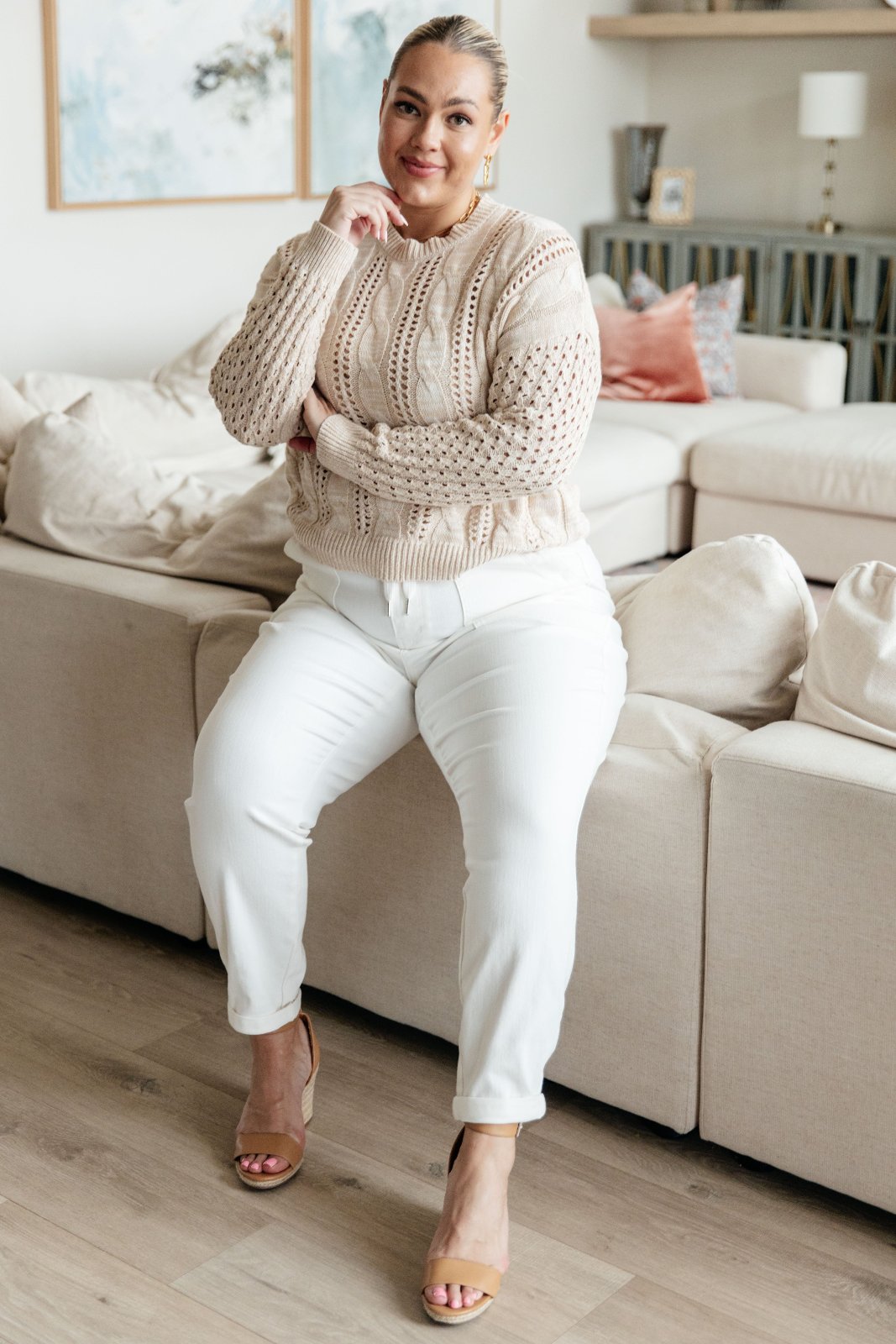 Medium Weight Cable Knit Sweater in Ivory on plus size model sitting on the back of a couch