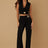 Woman wearing a black pant suit on a beige background