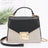 Black and gold handbag with chain detail on a white background