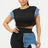 Woman wearing a black and denim outfit with a white background