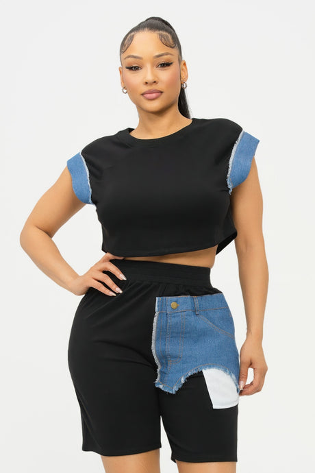 Woman wearing a black and denim outfit with a white background