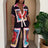 Woman wearing a colorful outfit with floral patterns in a room with a plant.