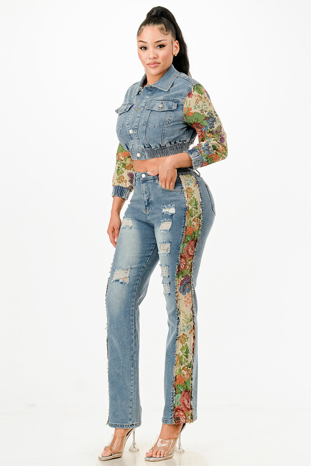 Woman wearing a denim outfit with floral sleeves and side panels on a white background