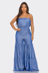 Woman wearing a blue strapless jumpsuit on a white background