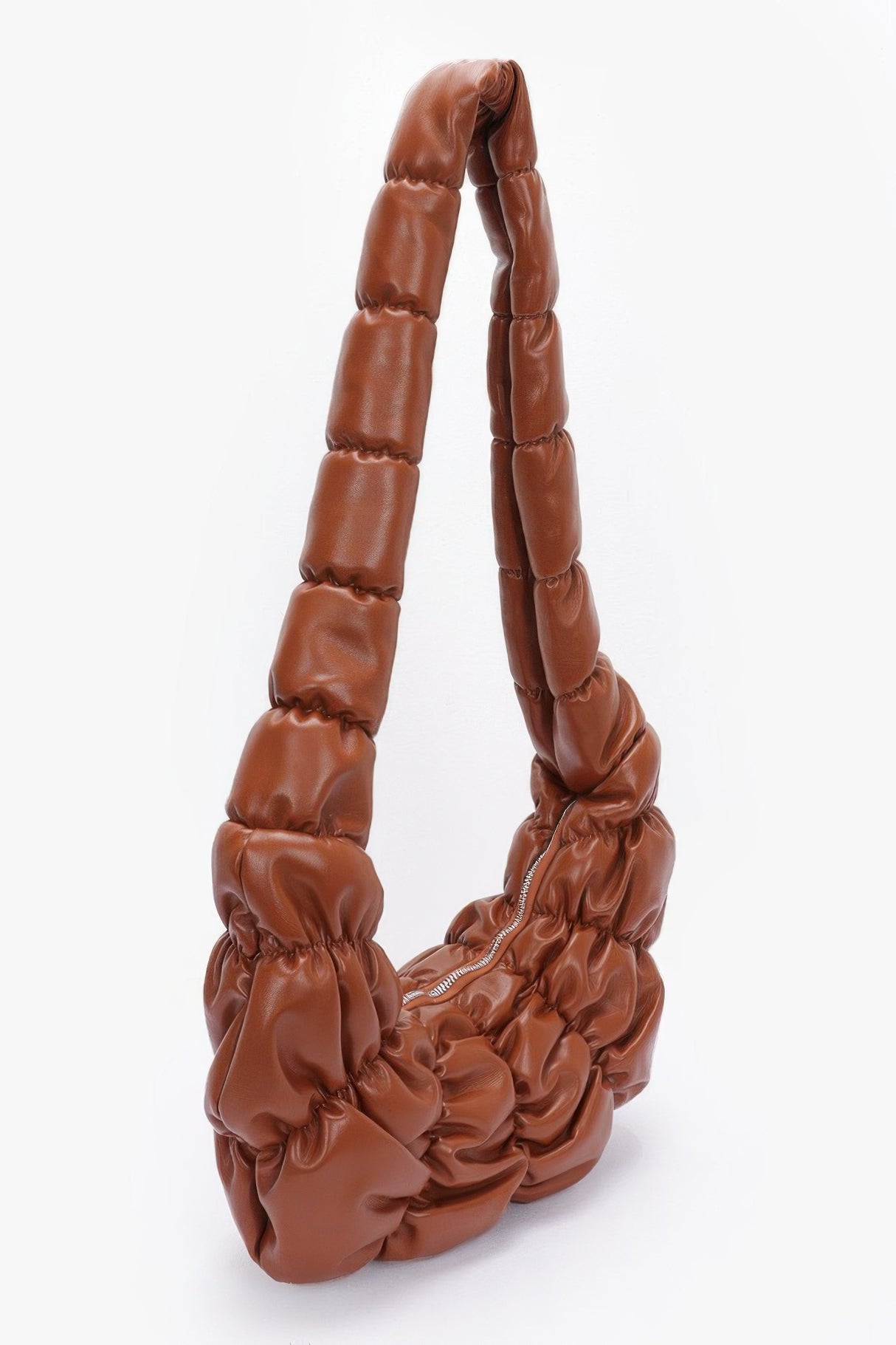 brown pleated faux leather crossbody bag with puffed-up handle against a white background