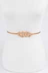 Gold belt with a knot design on a white mannequin.