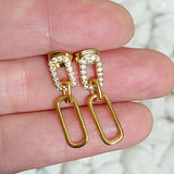 Gold Edge Dangle Earrings being held in a person's hand