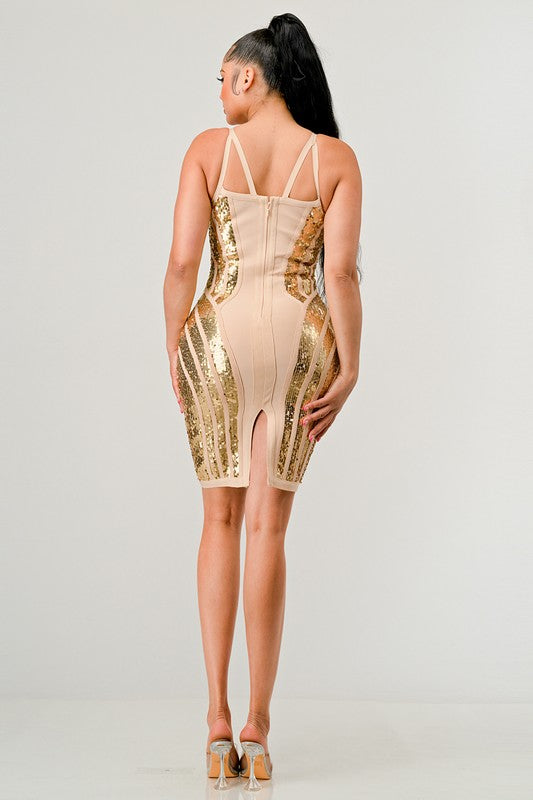 Woman wearing a beige and gold dress with sequin details on a plain background