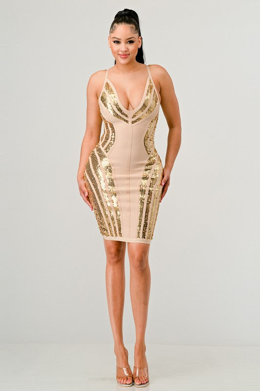 Woman wearing a beige and gold sequin dress on a gray background