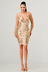 Woman wearing a beige and gold sequin dress on a gray background