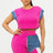 Woman wearing a bright pink short set with denim accents on a white background