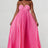 Woman wearing a pink pleated dress on a white background