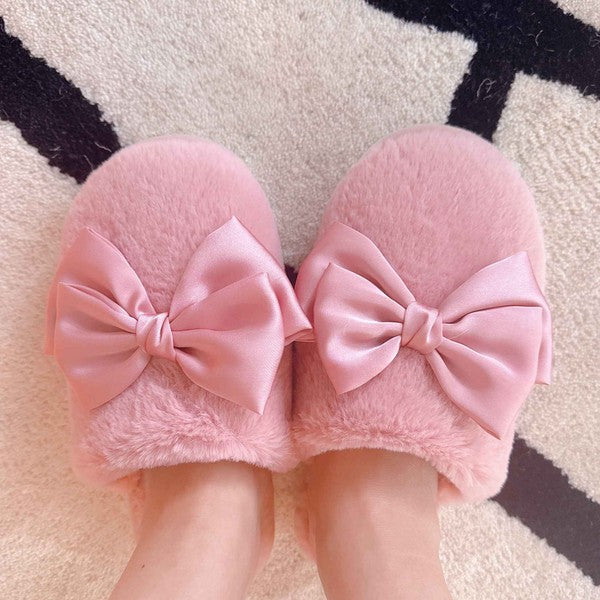 a model wearing a pair of pink fuzzy slippers