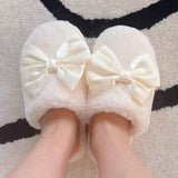 a model wearing a pair of cream colored fuzzy slippers