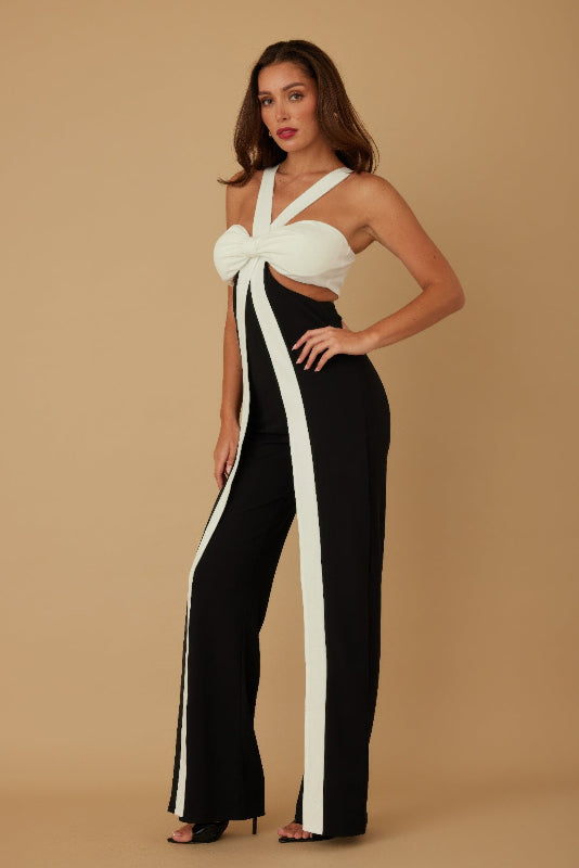 Woman wearing a black and white outfit with a bow detail on a beige background