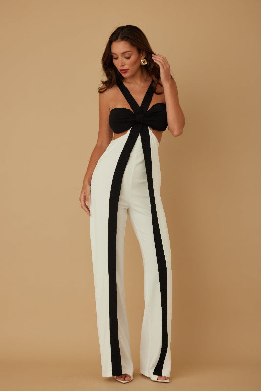 Woman wearing a black and white outfit against a beige background