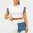 Woman wearing a white top and short with denim accents on a white background