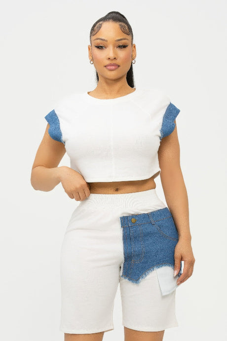 Woman wearing a white top and short with denim accents on a white background