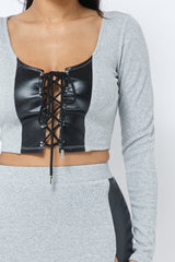 2 Piece Set with Cropped Long Sleeve Shirt with Pu Leather Detail and Crisscross Front Lace Up.  Matching Mini Skirt with Pu Leather Detail on Side with Crisscross Side Lace Up