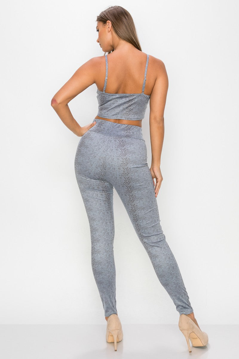 Top: A sleeveless crop top featuring an all-over embossed snake print, front tie, a sweetheart neckline, adjustable cami straps, and a square cut back. Bottom: A pair of casual skinny leggings featuring an all-over embossed snake print, elasticized high-rise waistband, and a full length.