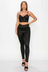 Top: A sleeveless crop top featuring an all-over embossed snake print, front tie, a sweetheart neckline, adjustable cami straps, and a square cut back.  Bottom: A pair of casual skinny leggings featuring an all-over embossed snake print, elasticized high-rise waistband, and a full length. 