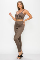 Top: A sleeveless crop top featuring an all-over embossed snake print, front tie, a sweetheart neckline, adjustable cami straps, and a square cut back.  Bottom: A pair of casual skinny leggings featuring an all-over embossed snake print, elasticized high-rise waistband, and a full length. 