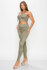 Top: A sleeveless crop top featuring an all-over embossed snake print, front tie, a sweetheart neckline, adjustable cami straps, and a square cut back.  Bottom: A pair of casual skinny leggings featuring an all-over embossed snake print, elasticized high-rise waistband, and a full length. 