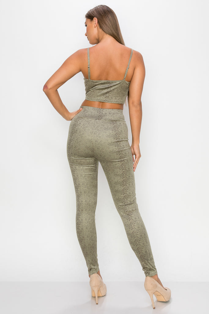 Top: A sleeveless crop top featuring an all-over embossed snake print, front tie, a sweetheart neckline, adjustable cami straps, and a square cut back.  Bottom: A pair of casual skinny leggings featuring an all-over embossed snake print, elasticized high-rise waistband, and a full length. 