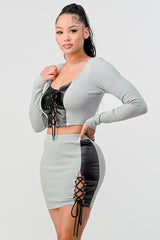 2 Piece Set with Cropped Long Sleeve Shirt with Pu Leather Detail and Crisscross Front Lace Up.  Matching Mini Skirt with Pu Leather Detail on Side with Crisscross Side Lace Up