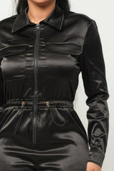 close up of model wearing Black Zip Front Satin Cargo Jogger Jumpsuit