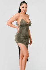 side view of model wearing a gold metallic glitter side slit midi dress with a white background