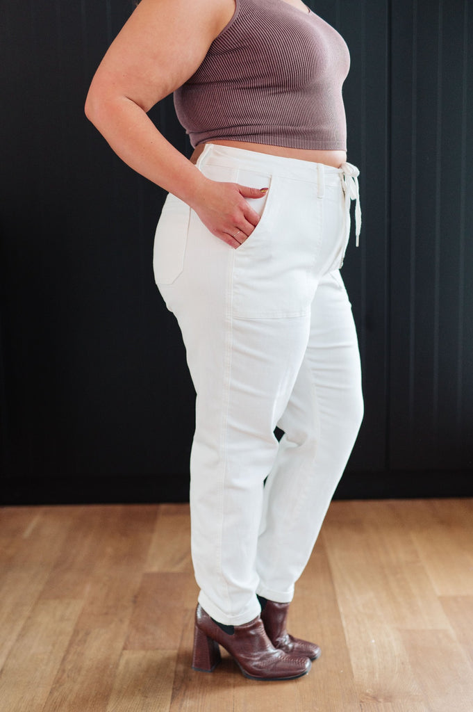 side view of plus size Classic High Rise Judy Blue Joggers in Off White paired with brown boots