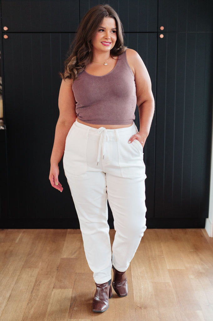 plus size model wearing Classic High Rise Judy Blue Joggers in Off White with brown boots and a tank top