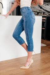 side view of model wearing medium wash judy blue High Rise Pull On Capri Jeans