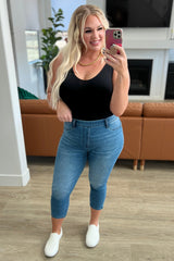 model taking a picture with her phone wearing model wearing medium wash judy blue High Rise Pull On Capri Jeans